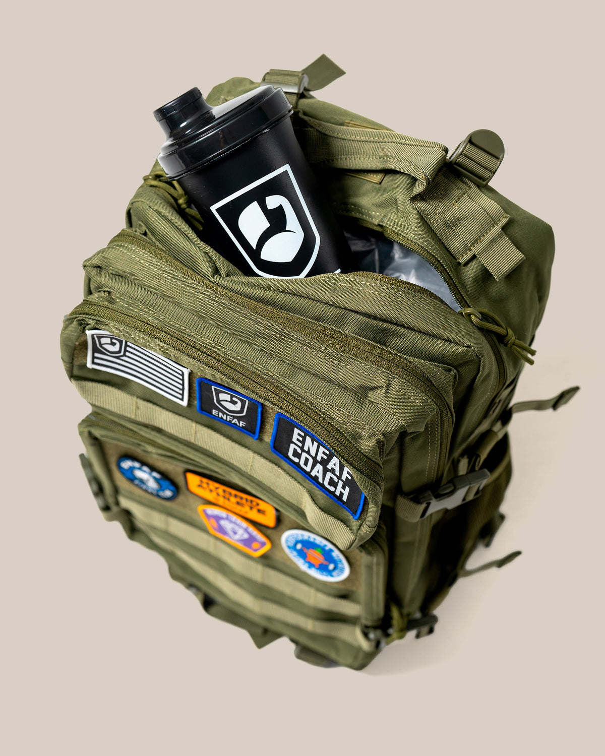 Mochila de gimnasio ENFAF Gear de 45 L en verde, detalle del compartimento abierto con un shaker